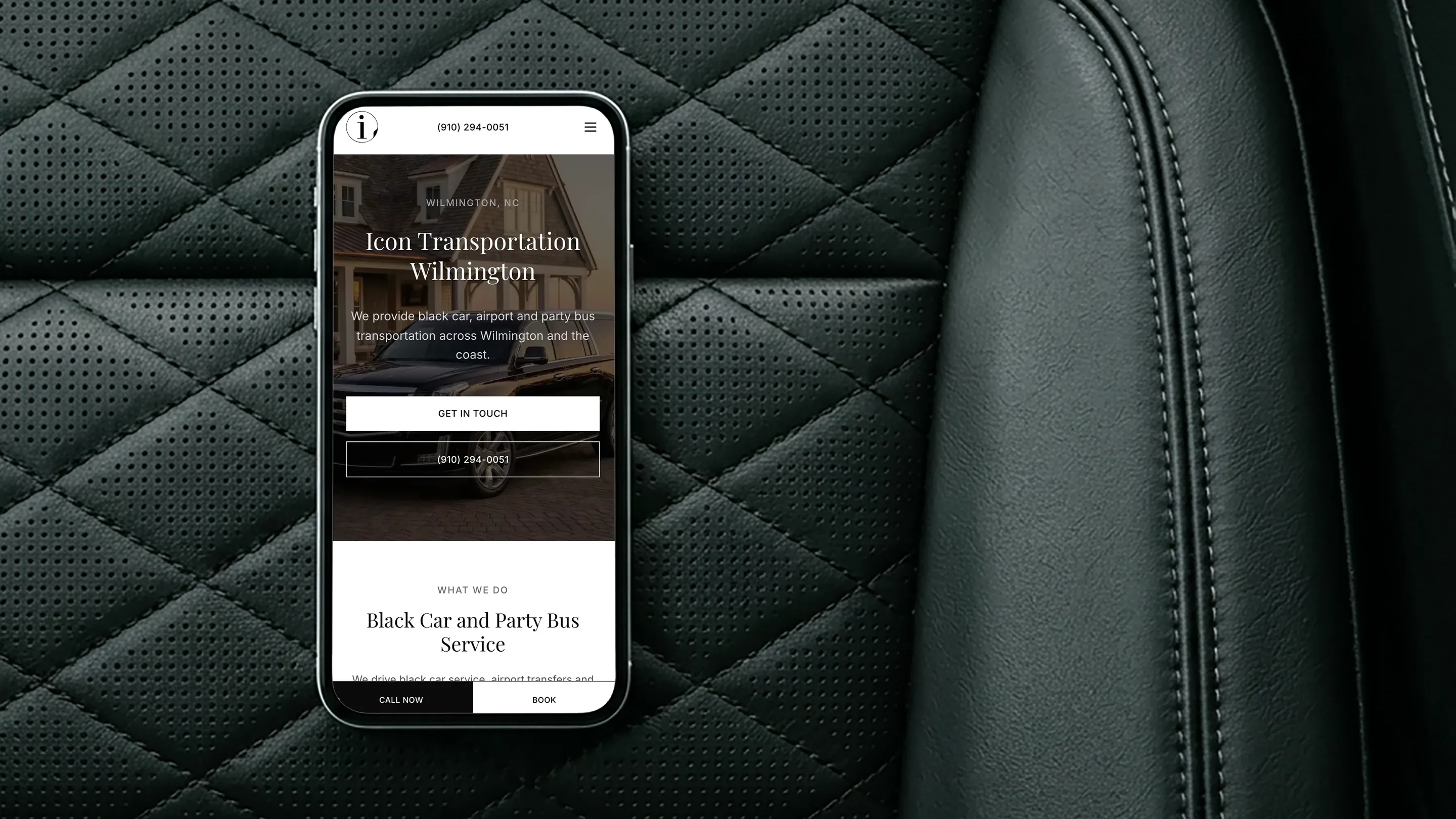Icon Transportation Wilmington website open on a phone lying on a black quilted leather car seat
